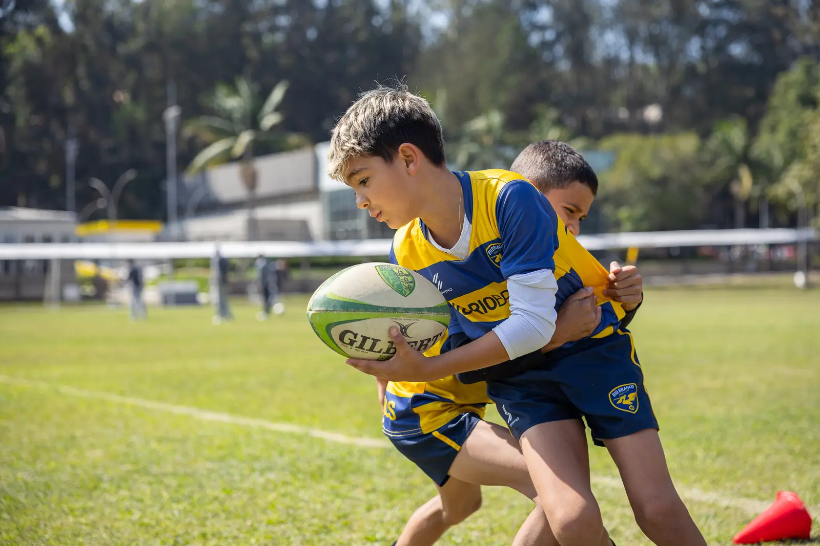 Unidade Granja Vianna: alunos praticando rugby no campo